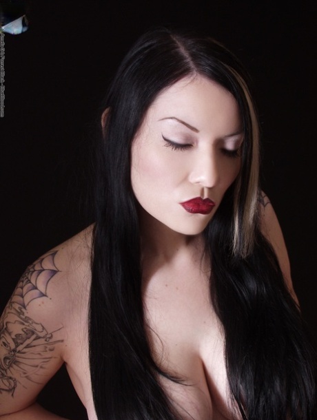 Goth girl Vamp Dahlia Dark holds her big naturals wearing a Cell mask