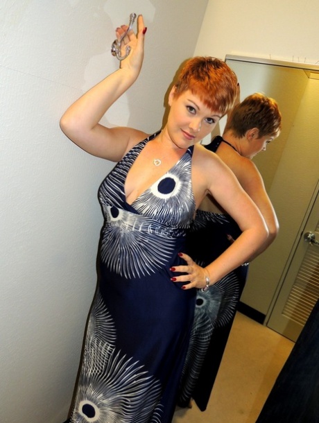 Middle-aged lady with short red hair Kali Devine licks a cock in a change room