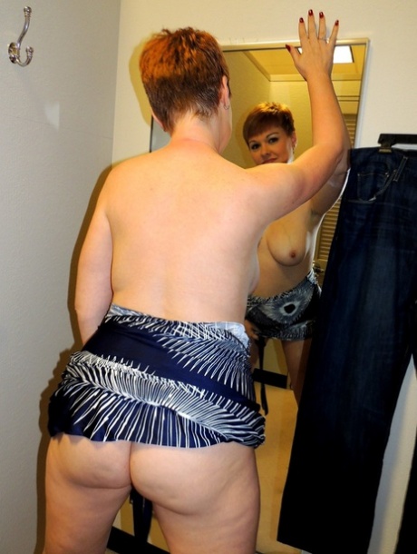 Middle-aged lady with short red hair Kali Devine licks a cock in a change room