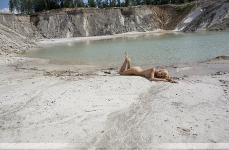Young blonde girl Nati wanders into the water while modeling in the nude