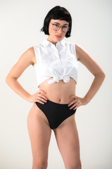 Dark haired chick Olive Glass removes glasses before standing naked