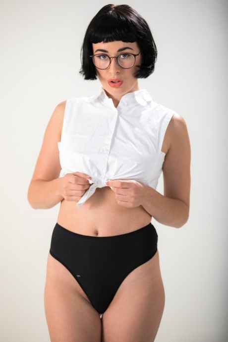 Dark haired chick Olive Glass removes glasses before standing naked