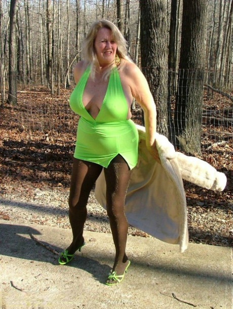 Older blonde amateur Adonna unleashes her enhanced boobs near a mature forest
