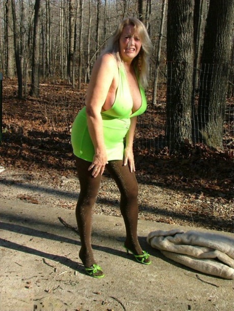 Older blonde amateur Adonna unleashes her enhanced boobs near a mature forest
