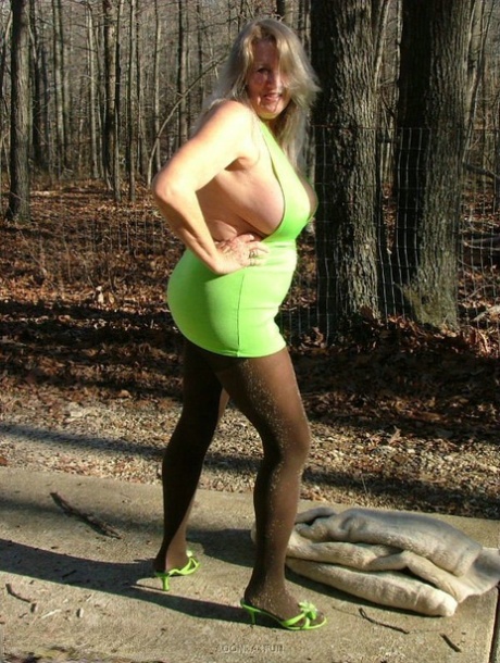 Older blonde amateur Adonna unleashes her enhanced boobs near a mature forest