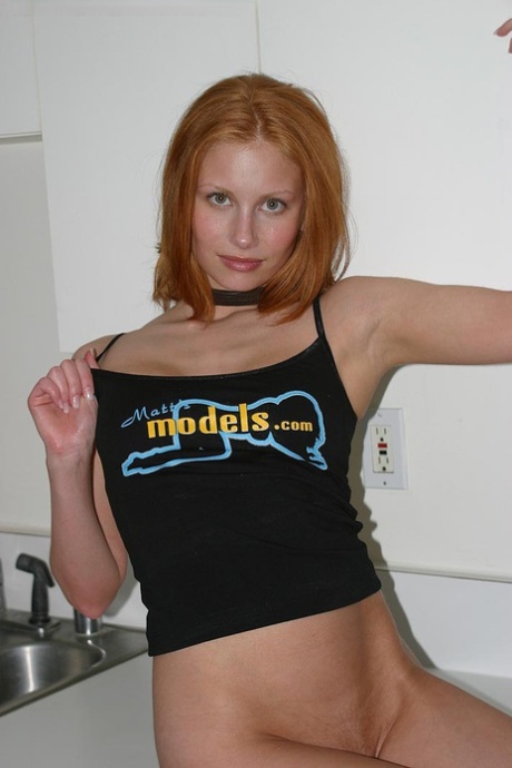 Natural redhead Anya lifts up a tank top to expose her natural tits