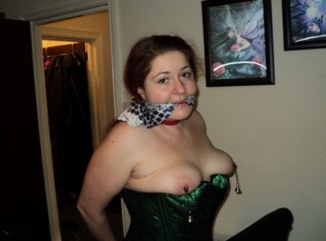 Chubby redhead sports a cleave gag with her wrists handcuffed behind her back