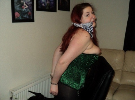 Chubby redhead sports a cleave gag with her wrists handcuffed behind her back