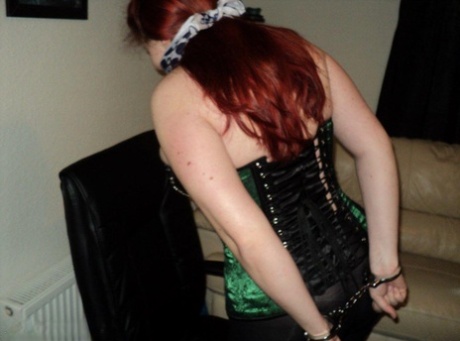 Chubby redhead sports a cleave gag with her wrists handcuffed behind her back