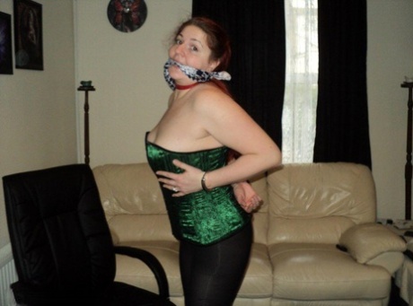 Chubby redhead sports a cleave gag with her wrists handcuffed behind her back