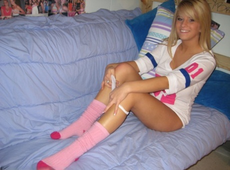 Young blonde girl takes off white panties in her socks after flashing boobage