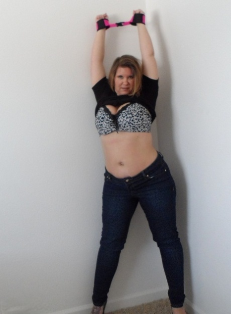 Thick amateur woman Busty Kris Ann shows her enhanced tits while cuffed