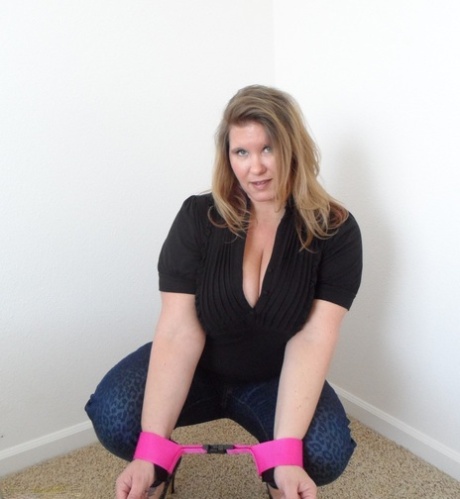 Thick amateur woman Busty Kris Ann shows her enhanced tits while cuffed