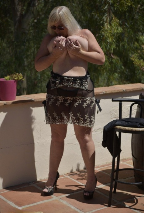Overweight mature blonde Melody exposes her huge boobs on a large balcony