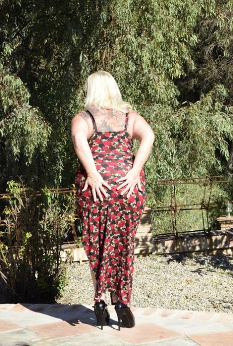 Fat blonde granny Melody looses her big butt from a long dress while outdoors