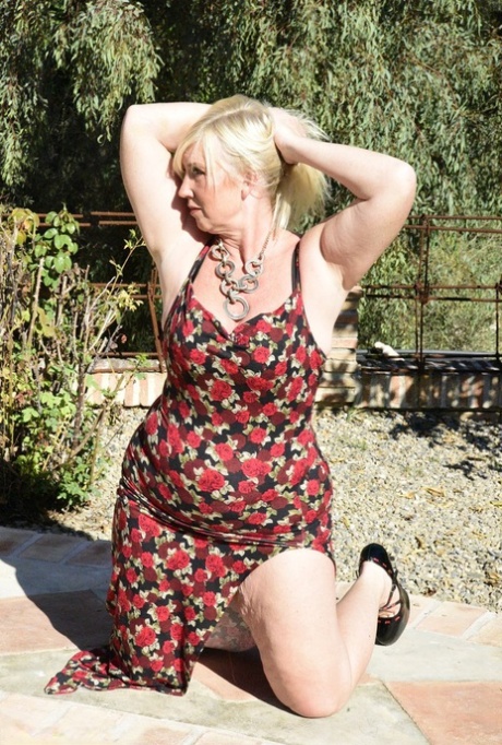 Fat blonde granny Melody looses her big butt from a long dress while outdoors