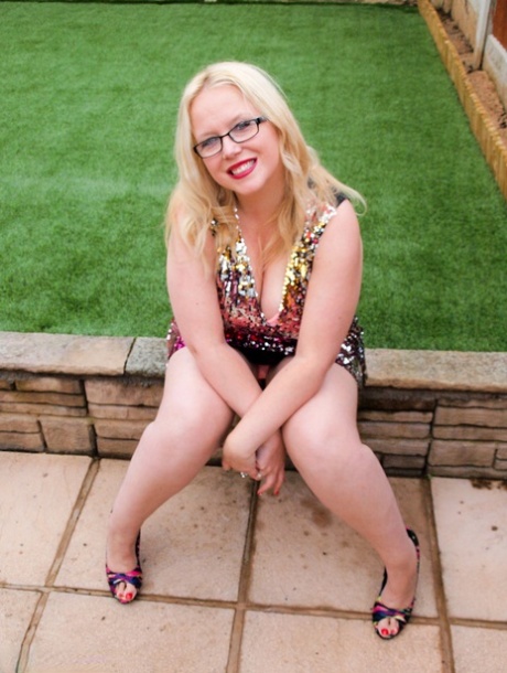 Overweight UK blonde Sindy Bust gets naked on a retaining wall in a backyard