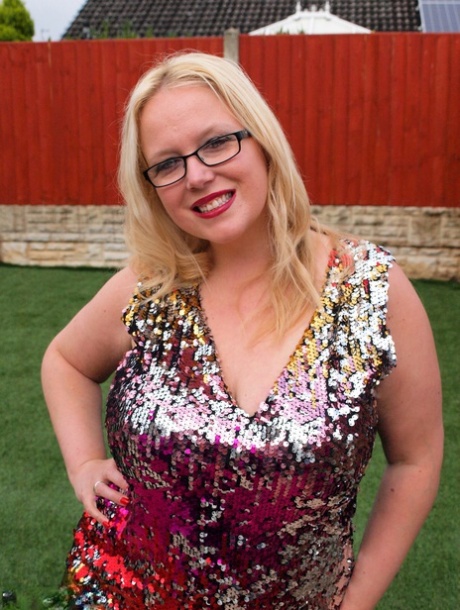 Overweight UK blonde Sindy Bust gets naked on a retaining wall in a backyard
