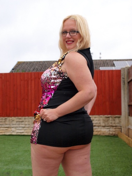 Overweight UK blonde Sindy Bust gets naked on a retaining wall in a backyard