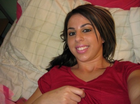 Pretty teen Heavenly Smut takes self shots on a bed in a teasing manner