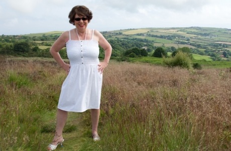 Mature lady Dirty Doctor goes topless on a blanket in a field