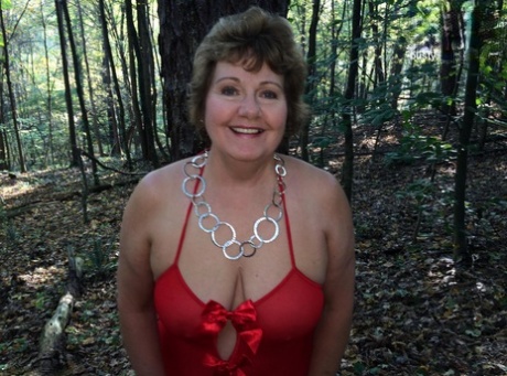 Older lady Busty Bliss gets completely naked while in a forest