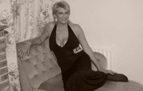 Mature blonde Dimonty holds her bare ass after freeing her tits and twat