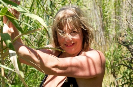 Mature British lady Speedy Bee takes off her bikini while in the undergrowth
