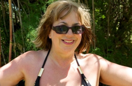Mature British lady Speedy Bee takes off her bikini while in the undergrowth
