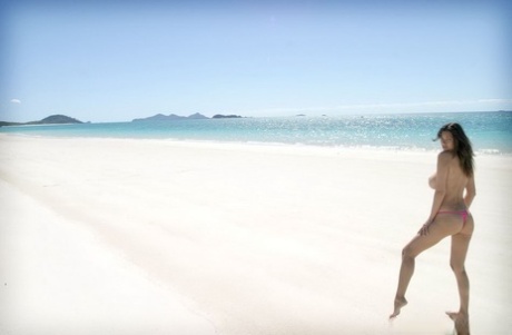 Busty Asian model Tera Patrick removes bikini bottoms to pose nude in the sea