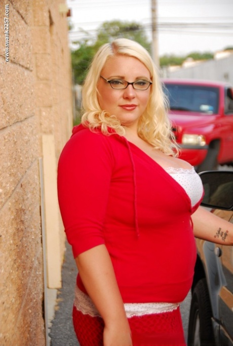 Fatty blonde in glasses smoking and stripping off her clothes