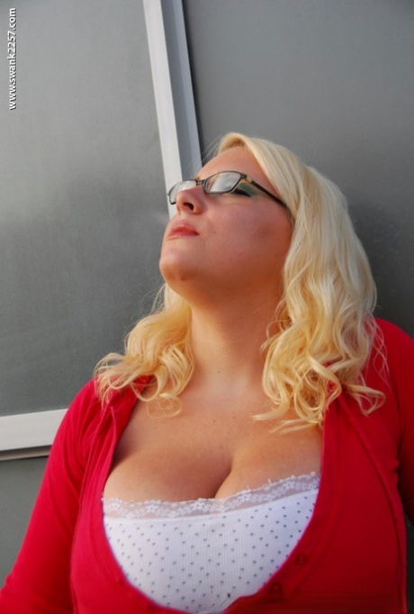 Fatty blonde in glasses smoking and stripping off her clothes