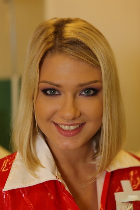 Blonde babe in nurse uniform Lucy Heart flashes with her natural boobies