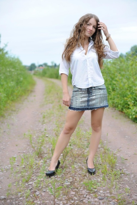 Sweet petite babe Ekitti lets out her big tits and poses outdoors in a solo