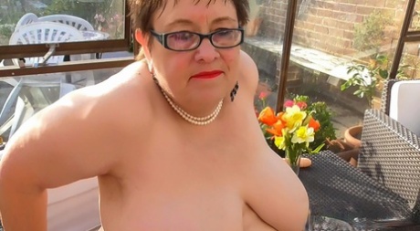 Short haired BBW in glasses Rita shows her huge breasts and masturbates