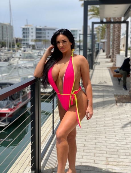 Babe with grand breasts Jessica Annelle poses in a pink swimsuit outdoors