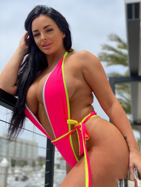 Babe with grand breasts Jessica Annelle poses in a pink swimsuit outdoors