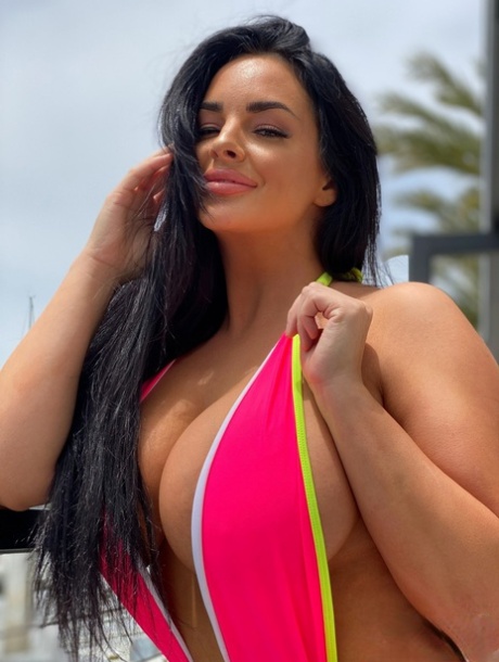 Babe with grand breasts Jessica Annelle poses in a pink swimsuit outdoors