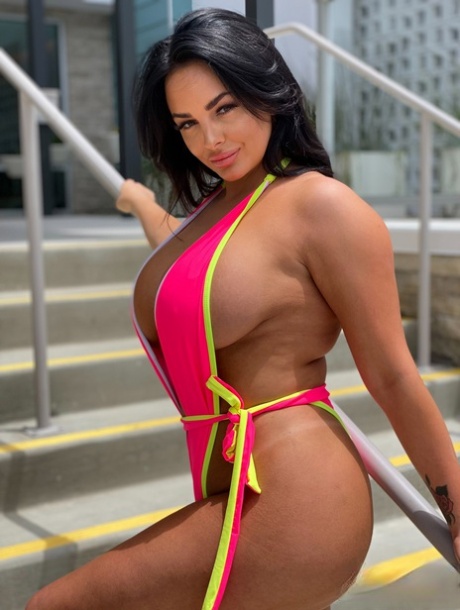 Babe with grand breasts Jessica Annelle poses in a pink swimsuit outdoors