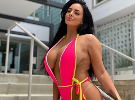 Babe with grand breasts Jessica Annelle poses in a pink swimsuit outdoors