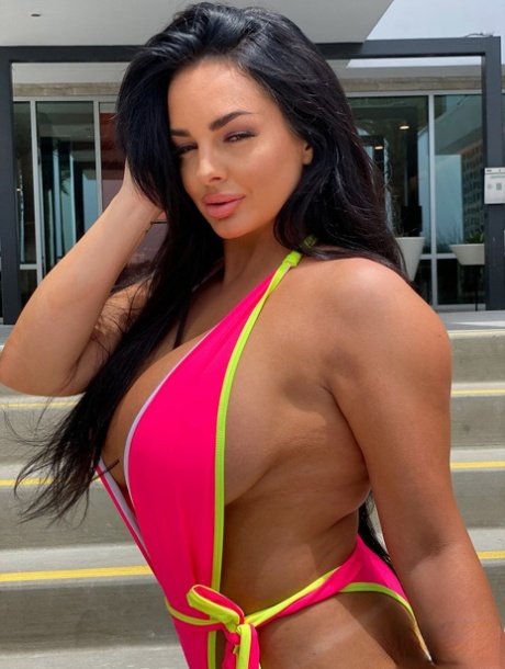 Babe with grand breasts Jessica Annelle poses in a pink swimsuit outdoors