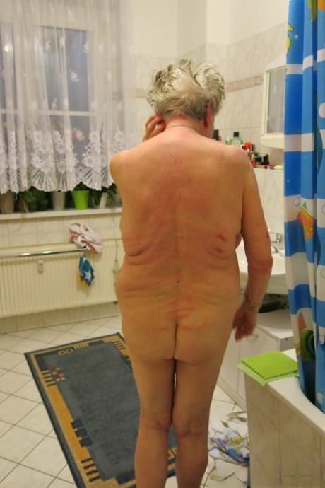 Short-haired granny Oma Geil strips and shows off her big saggy boobs
