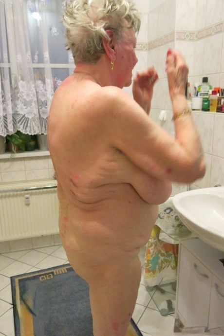 Short-haired granny Oma Geil strips and shows off her big saggy boobs